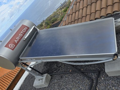 Termosolar instalado en un tejado, con vista al mar de fondo.